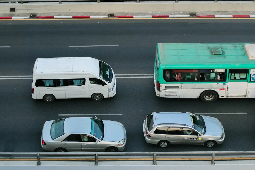 A green and white bus driving down a street