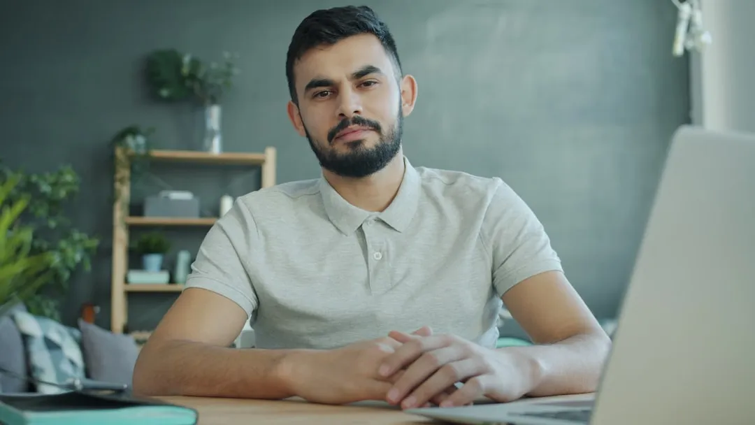 Man sitting at a desk with a laptop.